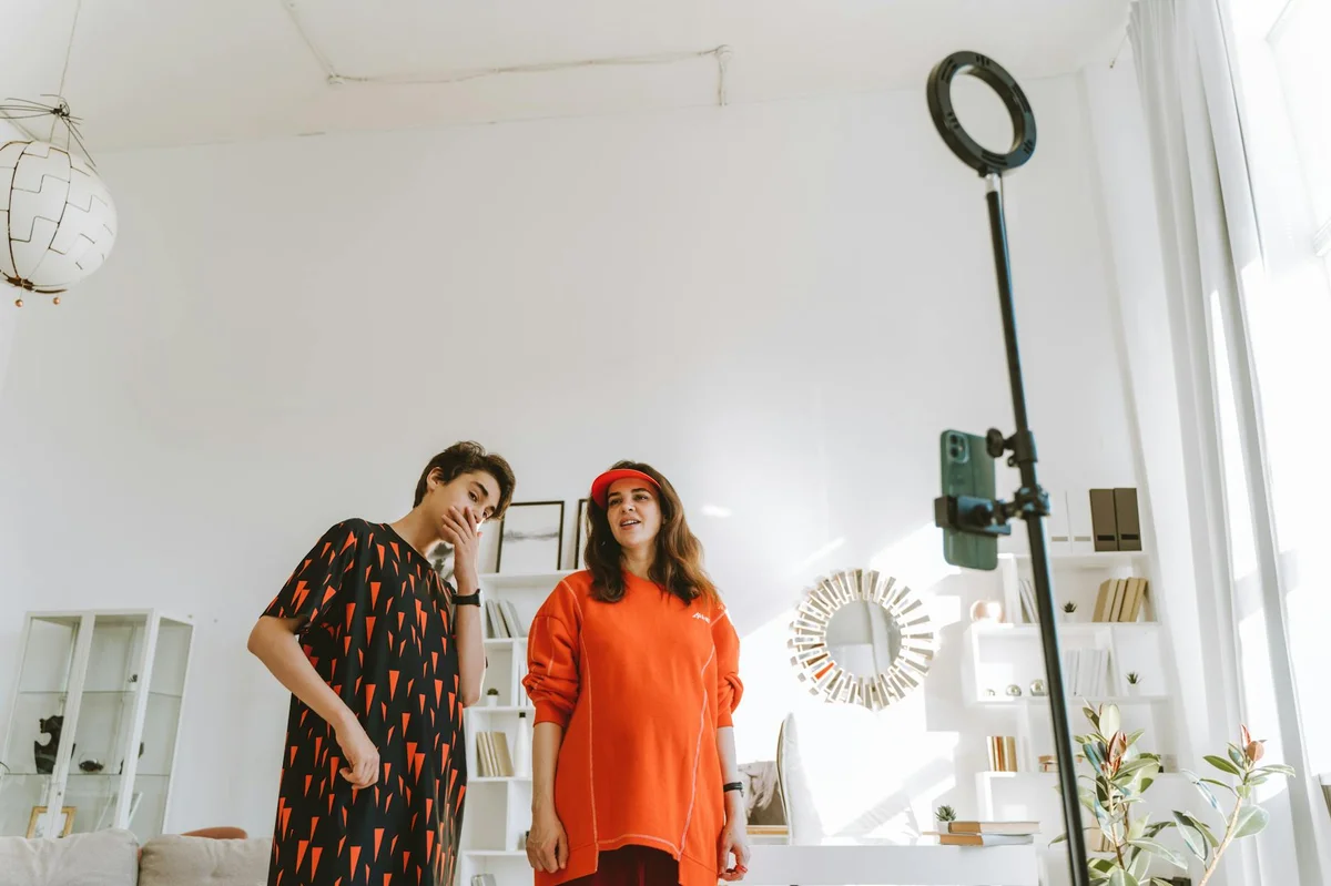 Sistemas y automatizacion para TikTok — A stylish mother and teenage son capture a moment in a chic, well-lit home studi