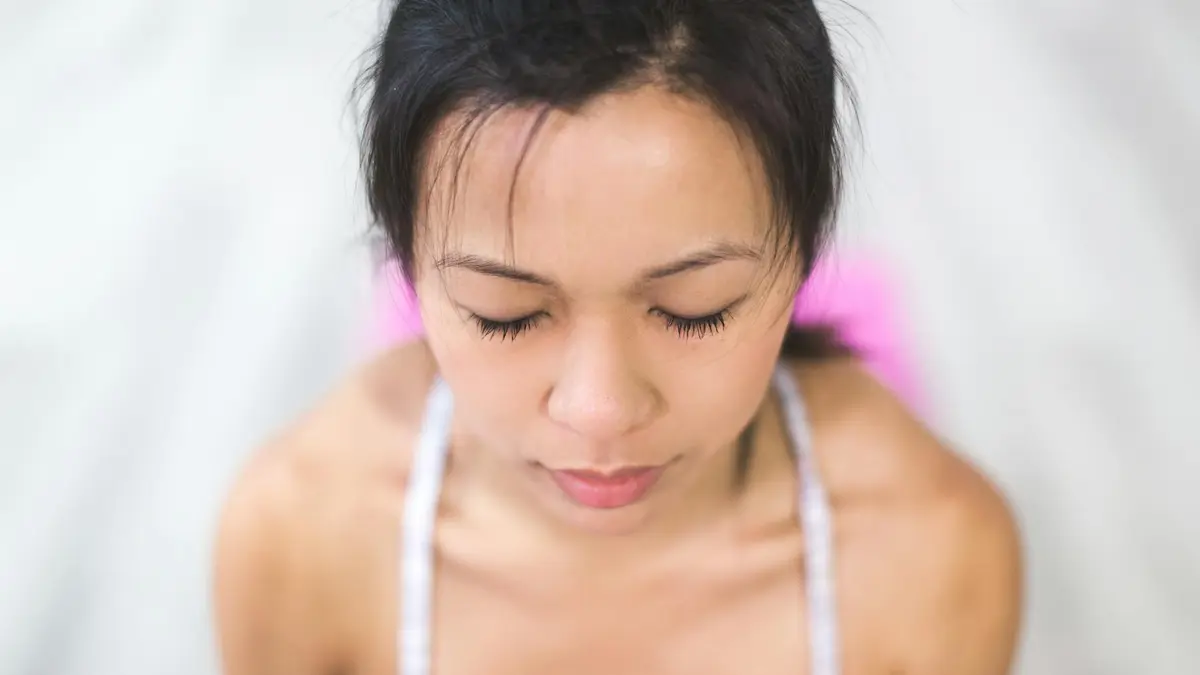 A young woman meditating indoors, focusing on relaxation and mindfulness.
